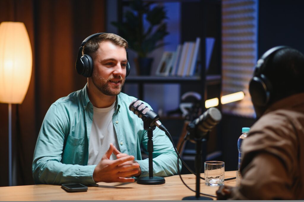 Two podcast hosts recording a conversation in the studio