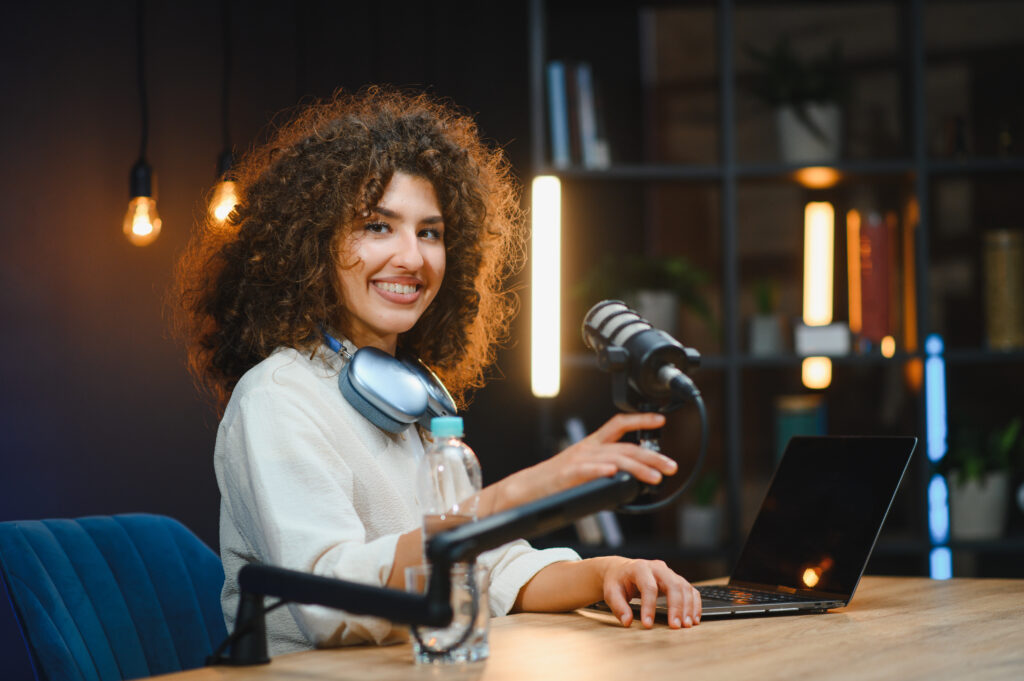 Podcast host recording with a microphone and laptop